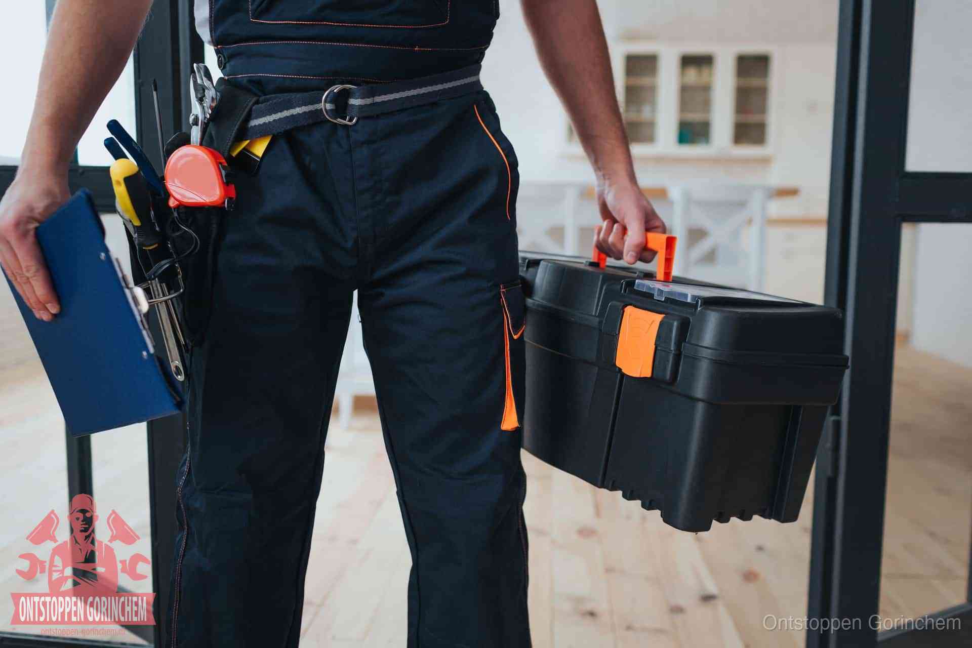 Een monteur met gereedschapsriem en klembord in een keuken, klaar om een transparante prijs voor het gootsteen ontstoppen in Gorinchem te geven