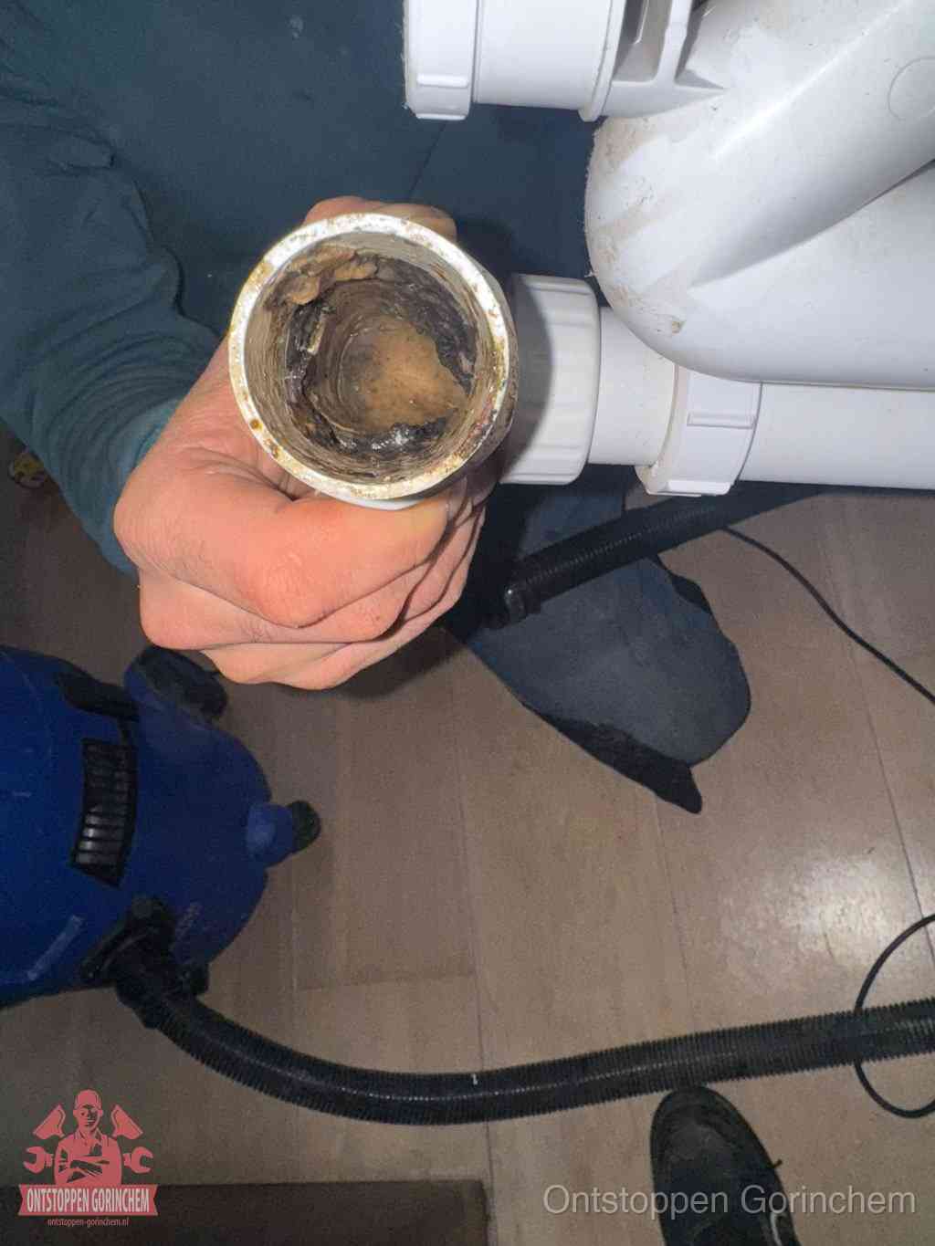 Een losgekoppelde afvoerbuis die van binnen volledig is dichtgeslibd met vet en aanslag, de meest voorkomende oorzaak van een verstopte gootsteen in Gorinchem