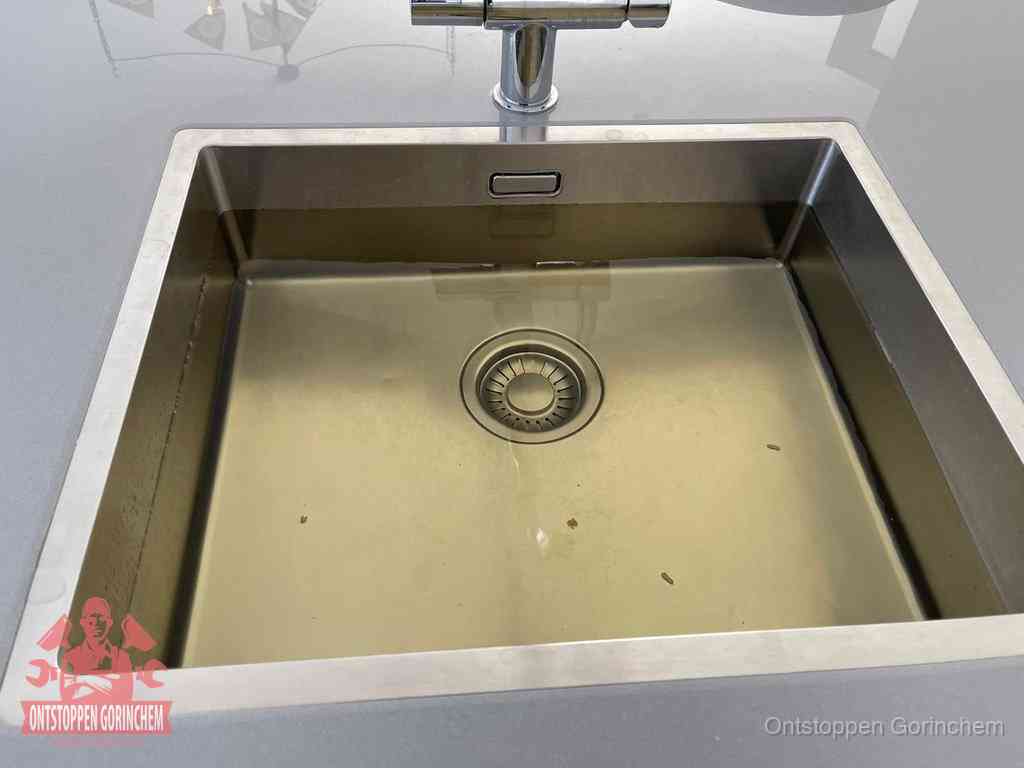 Stilstaand water in een rvs spoelbak dat niet wegloopt, een duidelijk signaal van een gootsteenverstopping in Gorinchem