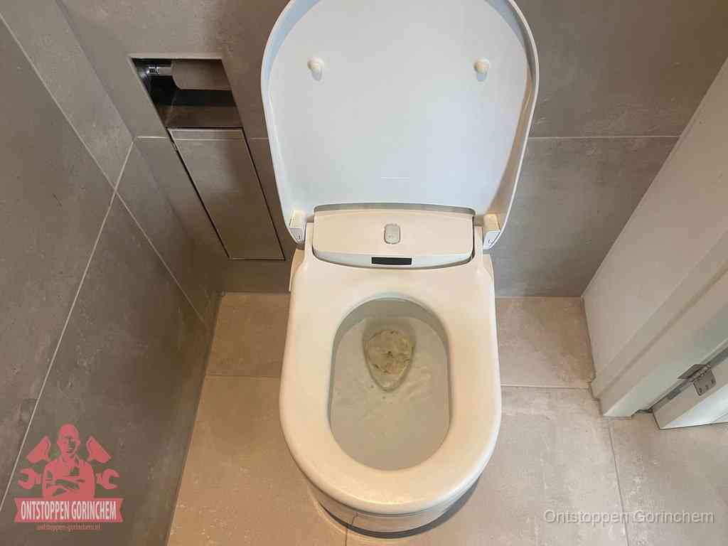 Een wit hangtoilet waarin een prop wc-papier op het water blijft drijven, een duidelijk signaal van een verstopte wc in Gorinchem