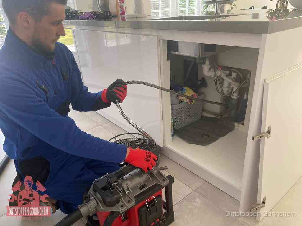 Een monteur reinigt de keukenafvoer grondig met een veermachine om terugkerende gootsteenverstoppingen te voorkomen in Gorinchem