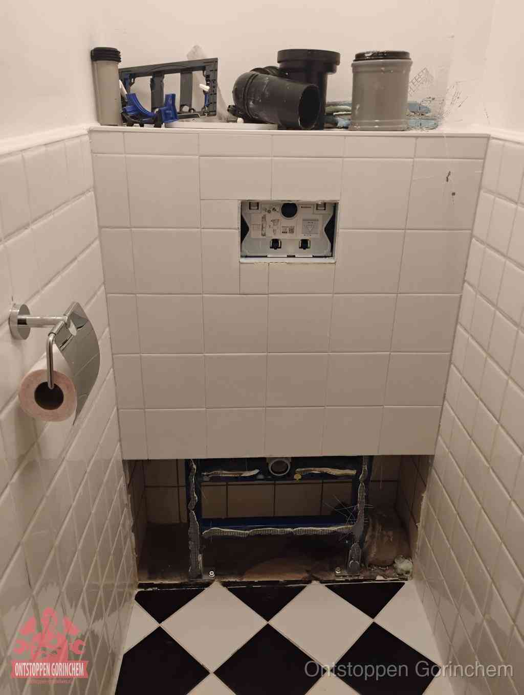 Een toiletruimte waar het hangtoilet en de inbouwreservoir-onderdelen zijn vrijgelegd voor onderhoud, periodiek nazicht voorkomt een wc-verstopping in Gorinchem
